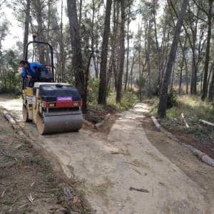 Rodillo compactador arreglando el firme de una pista de tierra forestal